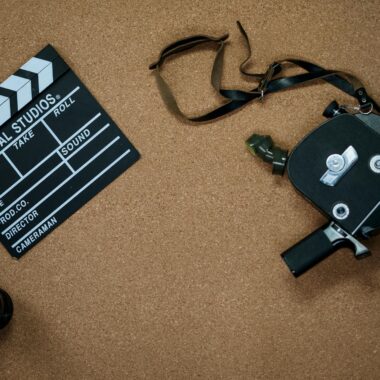 Vintage camera and clapboard on a cork board evoke a classic filmmaking vibe.